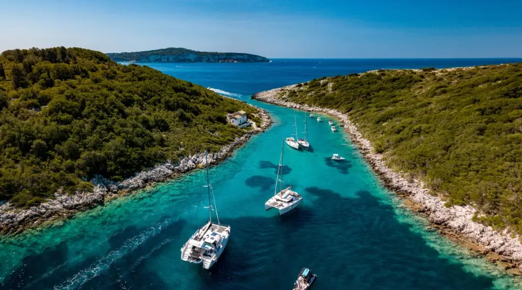 Sailing boats in the turquoise sea in Paxos Greece