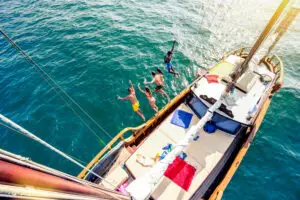 Aerial view of young people jumping from sailing boat