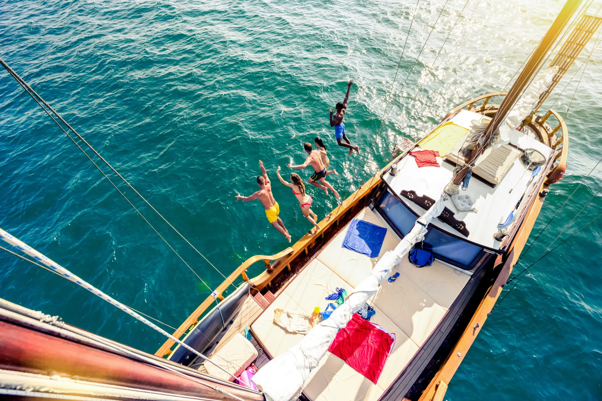 Aerial view of young people jumping from sailing boat